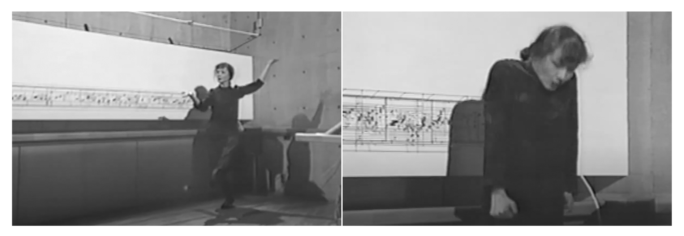 A person in dark attire performs dance movements indoors, set against a backdrop with abstract art.