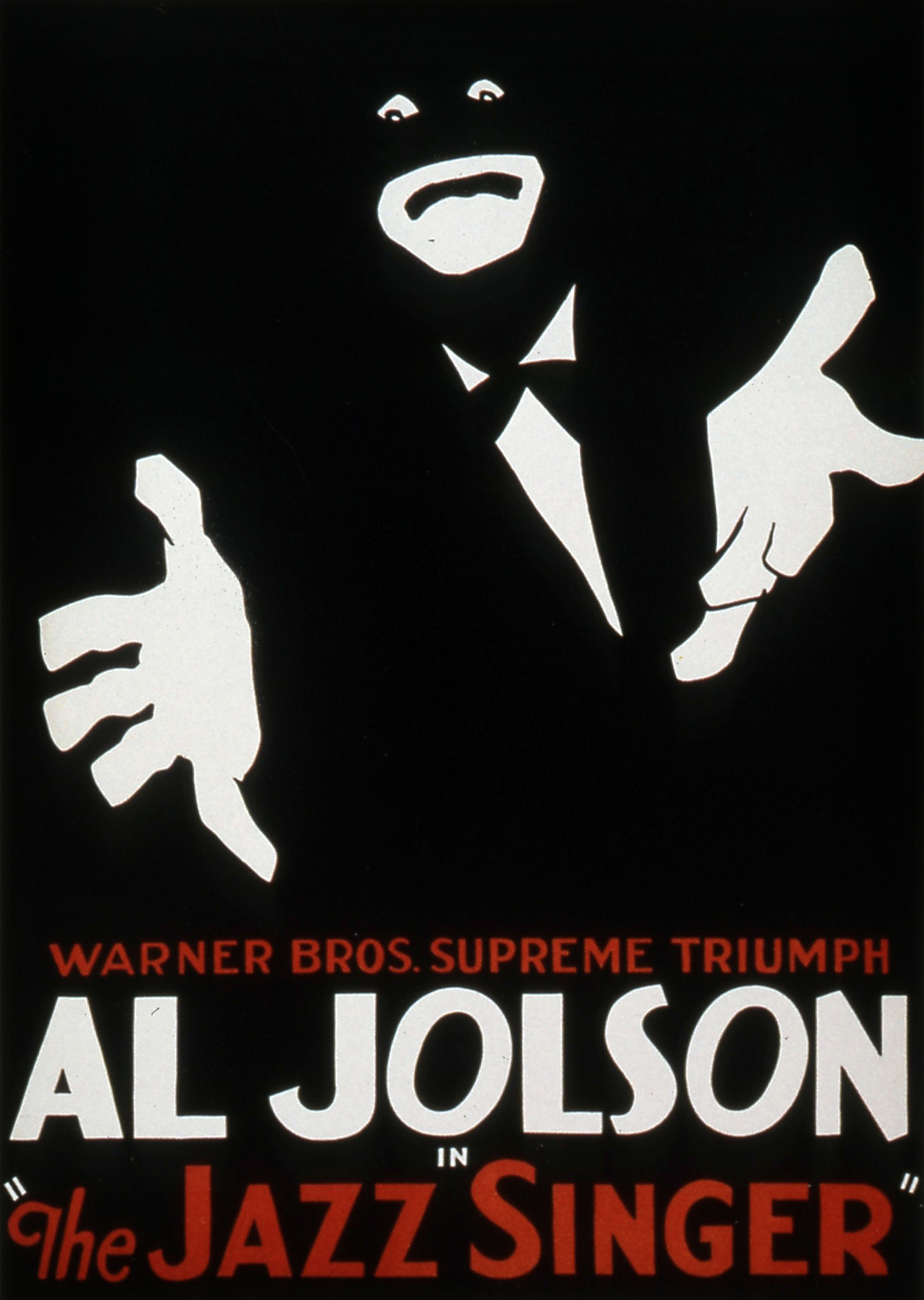 Ein Werbeplakat zeigt vor schwarzem Hintergrund die weißen Elemente einer Figur mit betonten Augen, betontem Mund und ausgestreckten Händen in weißen Handschuhen. Darunter steht  „AL Jolson" in weißen Großbuchstaben und „The Jazz Singer“ in roten Großbuchstaben.