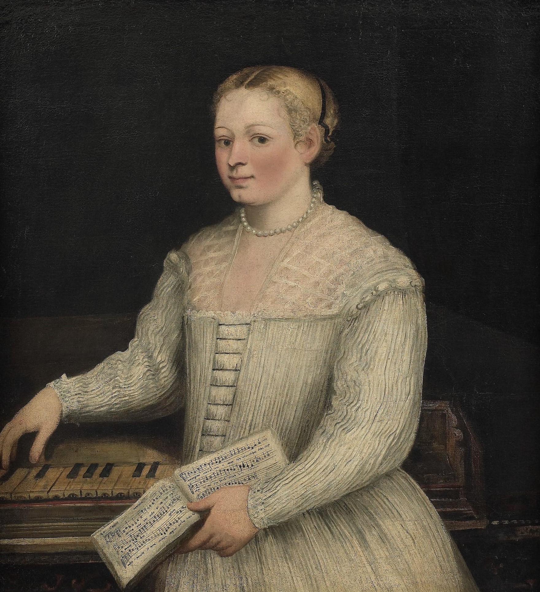 A Renaissance portrait of a young woman dressed in an elegant pale gown with lace details, standing beside a keyboard instrument. She holds an open music book in one hand while resting the other over the keys, gazing calmly at the viewer against a dark background.