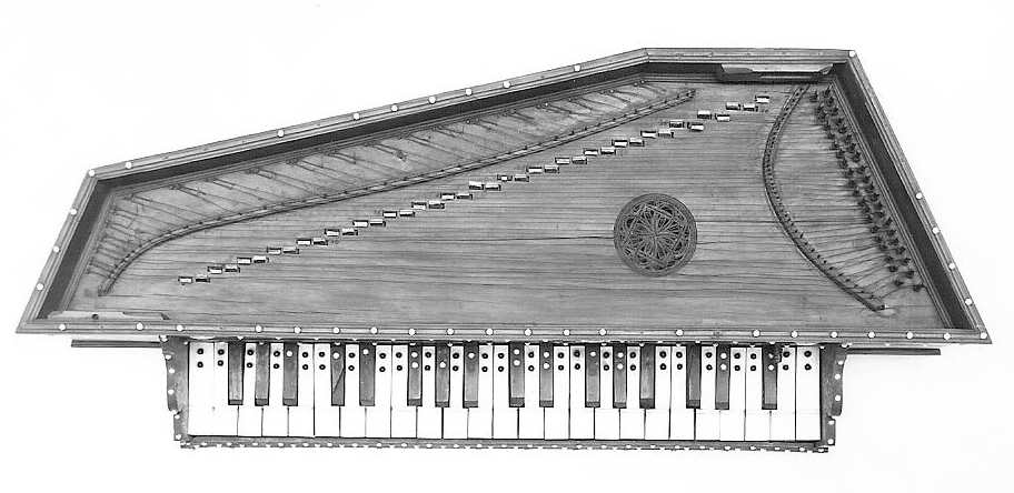 Black and white image of a virginal. It has a trapezoidal wooden body with a decorative rosette in the center and a single manual keyboard at the bottom. The strings are stretched diagonally across the soundboard, with tuning pegs on the right side.