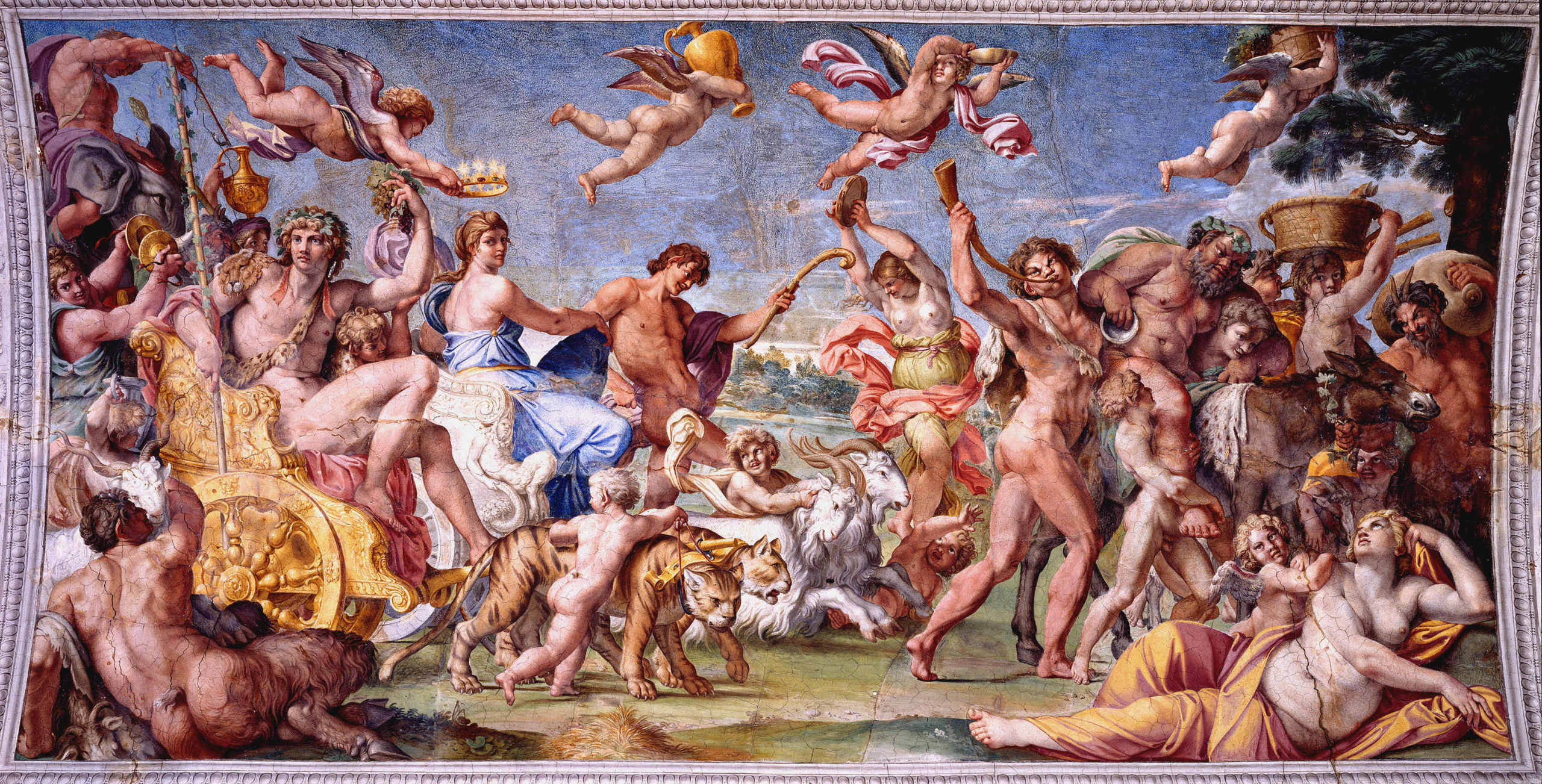 A vibrant Renaissance fresco depicting a grand Bacchic procession. At the center, Bacchus, crowned with ivy, rides a golden chariot pulled by tigers, accompanied by Ariadne draped in blue. Around them, satyrs, maenads, and putti celebrate with dancing, music, and flowing wine. Cherubs fly overhead carrying vessels and garlands, while animals such as goats and a donkey add to the lively scene.