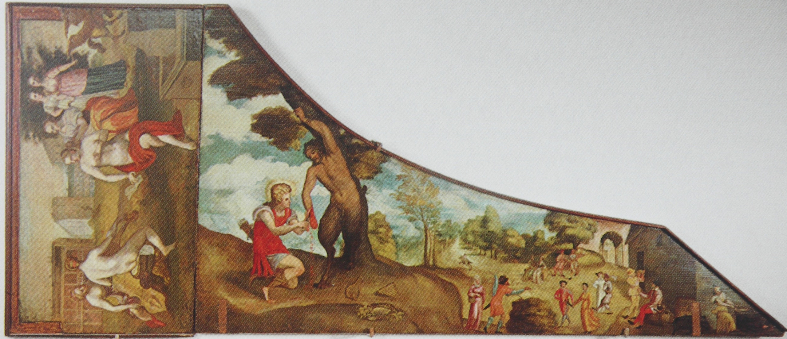 painted harpsichord lid depicting a mythological and pastoral scene. In the central panel, a figure dressed in red flays a satyr (Marsyas) beneath a tree in a wooded landscape. To the right, figures in colorful garments dance and converse in a lively village setting surrounded by trees and hills. On the left, partially nude figures recline and interact near architectural ruins.