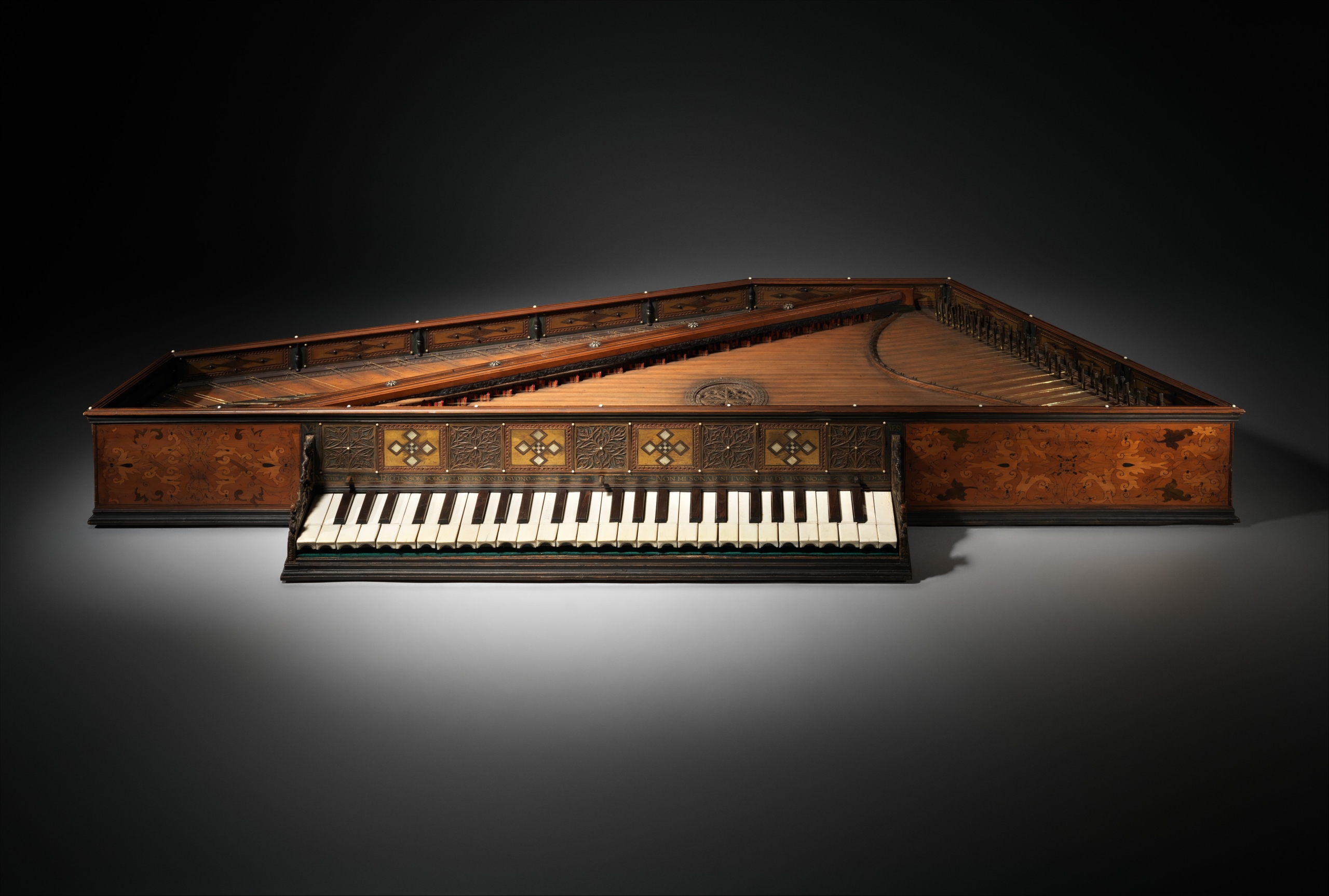 A richly decorated virginal or arpicordo belonging to Eleanora della Rovere. The instrument has an elegant trapezoidal shape with intricate inlay work and ornate patterns along its sides and keywell. The keyboard features alternating light and dark keys, and the soundboard displays fine craftsmanship typical of 16th-century Italian instrument making.