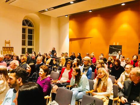 Das Publikum hört und schaut zu