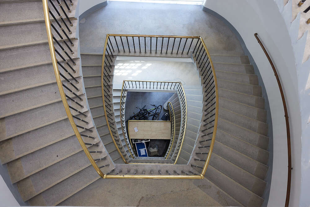 Foto. Stiegenhaus/Treppe von oben nach unten fotografiert - sieht einem Schneckenhaus ähnlich. 