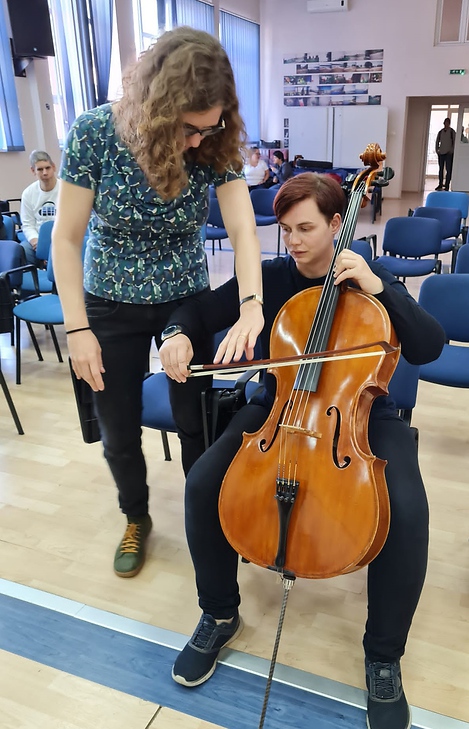 Marlene gibt einem Mitglied der All Stars Inclusive Tipps zur Haltung bzw. Spielanweisung des Cellos. 