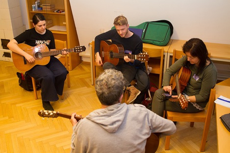 Vier Personen musizieren mit Gitarren. 