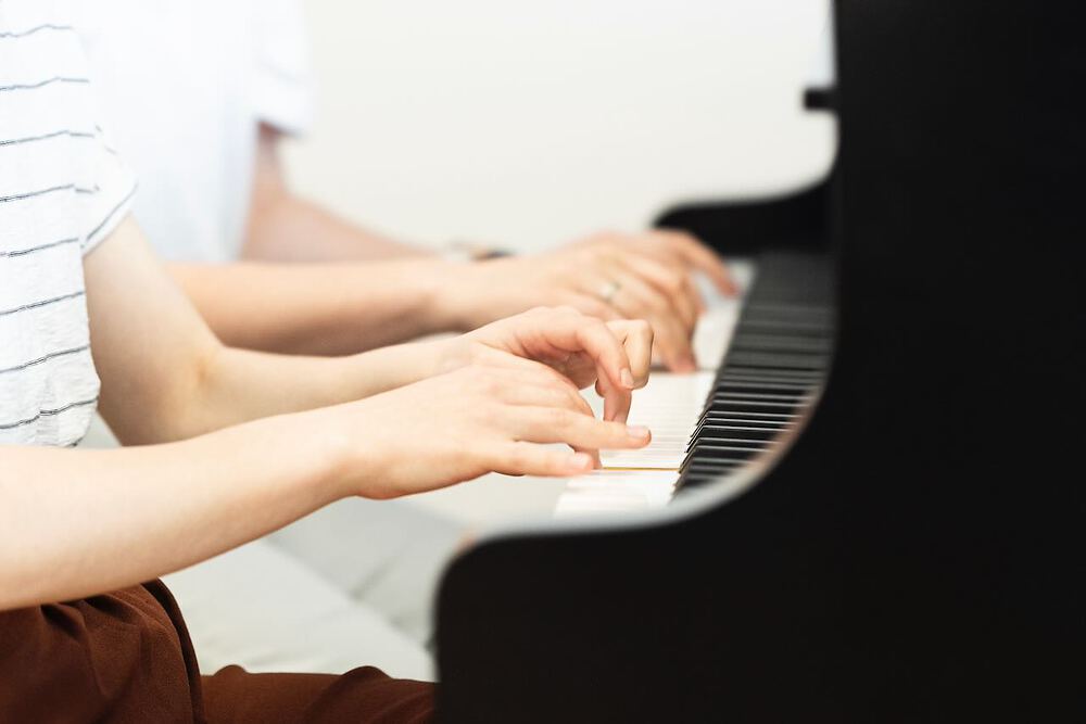Vier Hände am Klavier