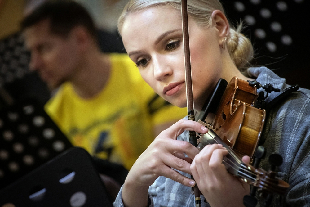 Eine junge blonde Geigerin spielt eine pizzicato-Passage.