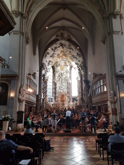 Der Chor singt vorm Altar in der Michaelerkirche.