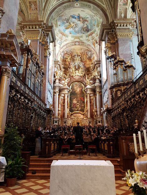 Der Chor singt vorm Altar in der Michaelerkirche.
